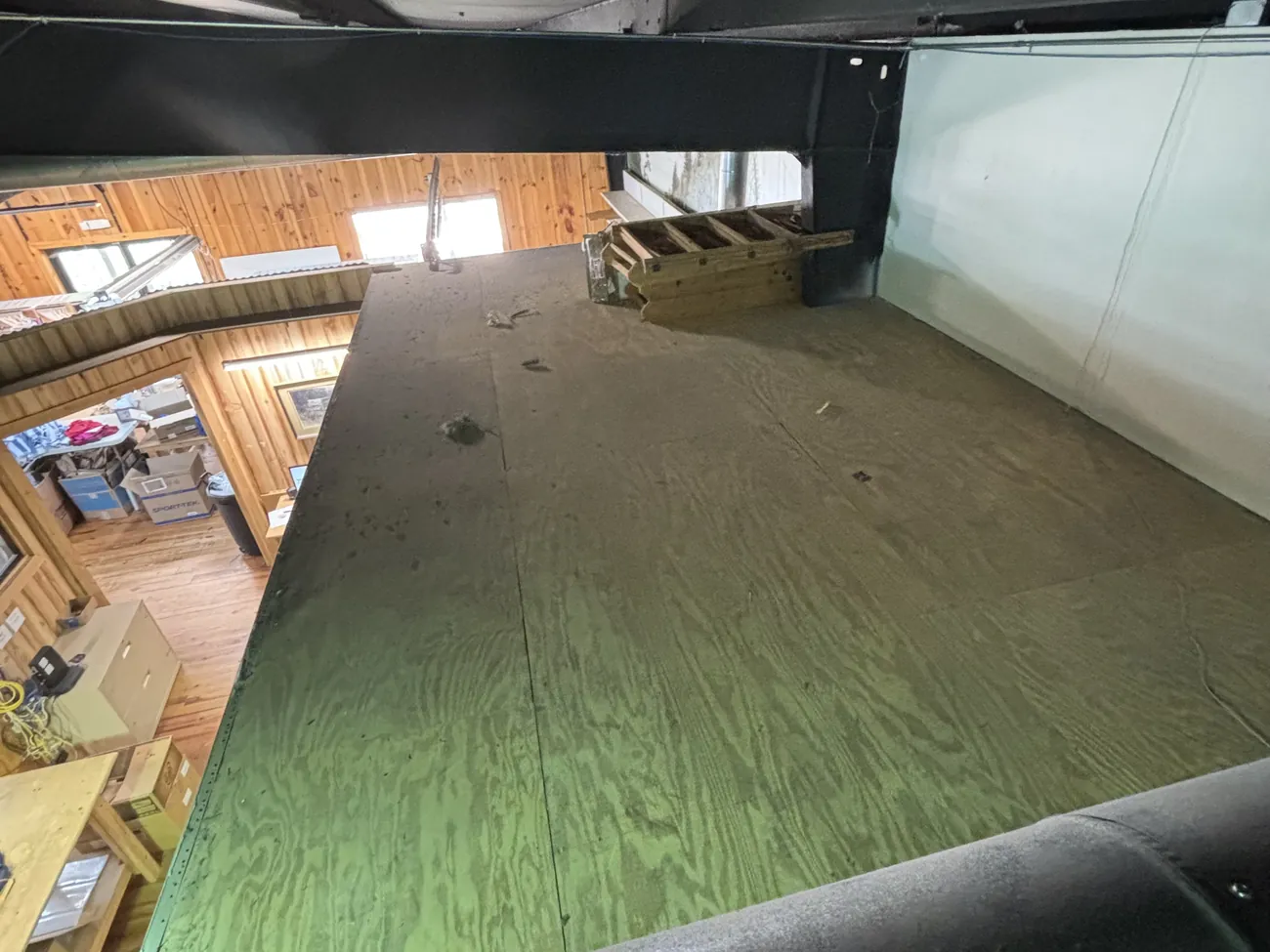 The same attic space after the boxes and bags were hauled away, with the plywood floor clear